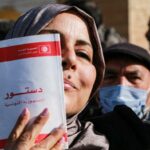 Una mujer sostiene una copia de la constitución tunecina durante una manifestación en Túnez contra los decretos del presidente Kais Saied el 13 de febrero de 2022.