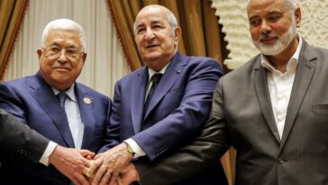 Una imagen proporcionada por la oficina de prensa de la Autoridad Palestina (PPO) el 5 de julio de 2022 muestra (de izquierda a derecha) al presidente palestino Mahmud Abbas estrechando la mano del presidente argelino Abdelmajid Tebboune y del líder del movimiento palestino Hamas Ismail Haniyeh.  (AFP)