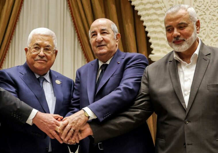 Una imagen proporcionada por la oficina de prensa de la Autoridad Palestina (PPO) el 5 de julio de 2022 muestra (de izquierda a derecha) al presidente palestino Mahmud Abbas estrechando la mano del presidente argelino Abdelmajid Tebboune y del líder del movimiento palestino Hamas Ismail Haniyeh.  (AFP)