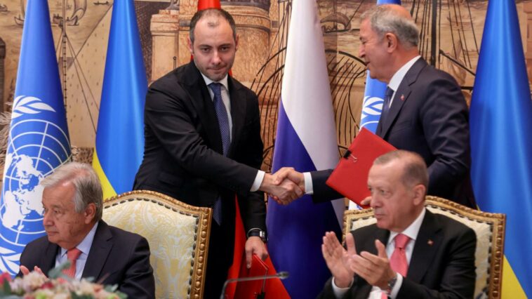 El ministro de Infraestructura de Ucrania, Oleksandr Kubrakov, y el ministro de Defensa de Turquía, Hulusi Akar, se dan la mano junto al secretario general de la ONU, Antonio Guterres, y al presidente turco, Recep Tayyip Erdogan, durante una ceremonia de firma en Estambul, el 22 de julio de 2022 (Reuters)
