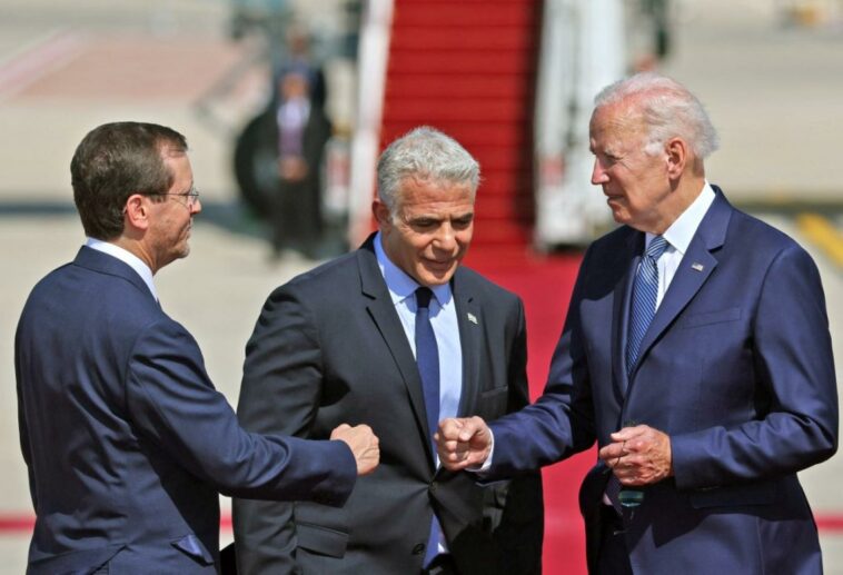 El presidente de los Estados Unidos, Joe Biden (derecha), choca los puños con el presidente de Israel, Isaac Herzog, mientras el primer ministro interino, Yair Lapid, observa, en el aeropuerto Ben Gurion de Israel en Lod, cerca de Tel Aviv, el 13 de julio de 2022. (AFP)