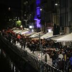 Porta Nuova es un centro de clubes y otros lugares de vida nocturna.  Las personas se muestran caminando en el canal Naviglio Grande, uno de los lugares favoritos para la vida nocturna en Milán.