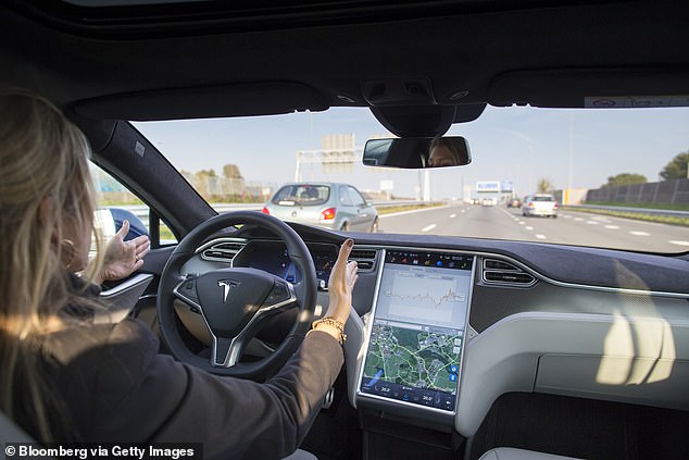 El paquete de capacidad de conducción autónoma completa está disponible para adaptarse a los vehículos Tesla, lo que les permite conducir, estacionar y detenerse en semáforos o señales.  En la imagen de arriba, un empleado conduce un Tesla Model S con manos libres en una autopista de Ámsterdam.