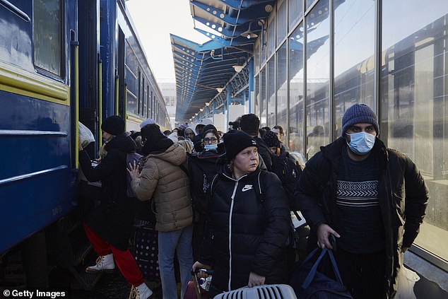 Los residentes locales se apresuran a abordar un tren de evacuación que se dirige al oeste de Ucrania el 26 de febrero.
