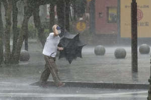 Un hombre camina por la calle bajo la fuerte lluvia causada por la tormenta tropical Meari en Hamamatsu, Japón central, 13 de agosto de 2022 (Kyodo)