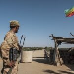 A member of the Amhara Special Forces watches on at the border crossing with Eritrea while where an Imperial Ethiopian flag waves, in Humera, Ethiopia, on November 22, 2020.