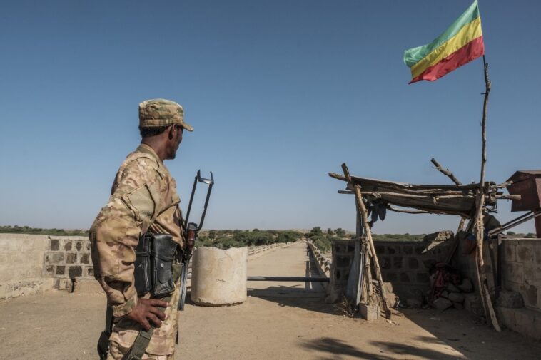 A member of the Amhara Special Forces watches on at the border crossing with Eritrea while where an Imperial Ethiopian flag waves, in Humera, Ethiopia, on November 22, 2020.