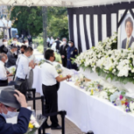 La gente ofrece flores en un puesto instalado en un parque en Tokio el 27 de septiembre de 2022, para presentar sus respetos al asesinado ex primer ministro japonés Shinzo Abe, ya que su funeral de estado tendrá lugar en el cercano salón Nippon Budokan más tarde en el día.  (Kiodo)