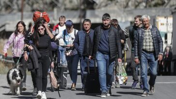 Éxodo: hombres y mujeres rusos con su equipaje caminan por una carretera después de pasar por la aduana en el puesto de control fronterizo entre Georgia y Rusia de Verkhnii Lars, Georgia, el 27 de septiembre de 2022