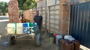 Tap water supply is unreliable in Chitungwiza in Harare. Some people now make a living carrying water for residents.