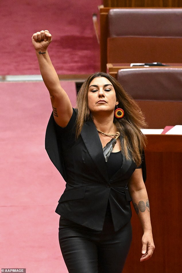 La senadora de los Verdes por Victoria Lidia Thorpe levanta el puño durante la ceremonia de juramento en la cámara del Senado en la Casa del Parlamento