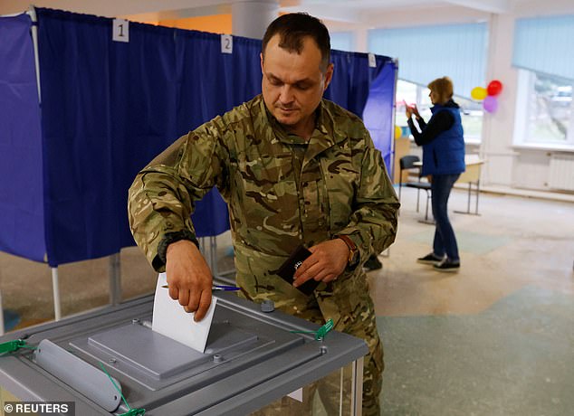 Un hombre con uniforme militar emite su voto en un colegio electoral durante un referéndum sobre la unión de la autoproclamada República Popular de Donetsk (RPD) a Rusia, en Donetsk, que según los medios estatales rusos ha votado en un 98 por ciento para unirse a Rusia con 14 por ciento de los votos contados