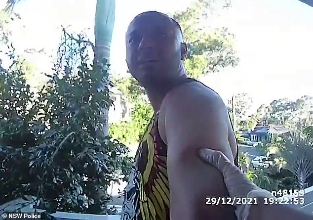 Las imágenes de la cámara corporal de la policía muestran al miembro de Hells Angel, Mustafa Hafizi, de 34 años, esposado y conducido fuera de su casa de Greystanes en el oeste de Sydney el 29 de diciembre de 2021.