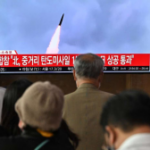 La gente mira una pantalla de televisión que muestra una transmisión de noticias con imágenes de archivo de una prueba de misiles de Corea del Norte, en una estación de tren en Seúl el 4 de octubre de 2022. Corea del Norte disparó un misil balístico de alcance medio el 4 de octubre, que voló sobre Japón, Seúl y Tokio dijo, una escalada significativa a medida que Pyongyang aumenta su bombardeo de prueba de armas sin precedentes.  (AFP)