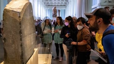 Visitors view the Rosetta Stone at the British Museum in London on July 26, 2022.