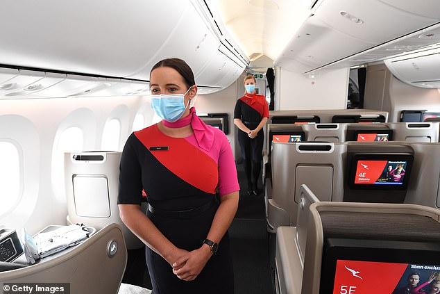 Alrededor de 1500 tripulantes de cabina de Qantas están preparados para llevar a cabo prohibiciones de trabajo y huelgas después de que la aerolínea supuestamente amenazara con subcontratar trabajos si los trabajadores no firmaban un nuevo acuerdo (en la foto, tripulantes de cabina a bordo de un vuelo de Qantas)