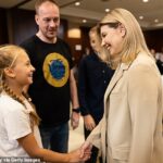 La primera dama de Ucrania, Olena Zelenska, le da la mano a la eufórica hija de Denys Shleha después de que los cinco comandantes de Azovstal finalmente se reunieran con sus familias después de 19 semanas como prisioneros de guerra.