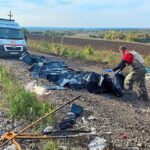 Un voluntario coloca el cuerpo de las personas muertas en un sitio de un convoy civil, que según el Servicio de Seguridad del Estado de Ucrania fue alcanzado por un bombardeo de las tropas rusas en medio del ataque de Rusia contra Ucrania, cerca de la aldea de Kurylivka en la región de Kharkiv.