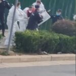 Una pieza de video en una rara muestra de disidencia vio a policías y funcionarios con trajes de protección contra materiales peligrosos deteniendo a una persona y golpeando a otra con palos.