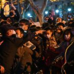 Manifestantes y policías de Shanghái se empujan mientras aumenta la ira por las restricciones de COVID-19 en China