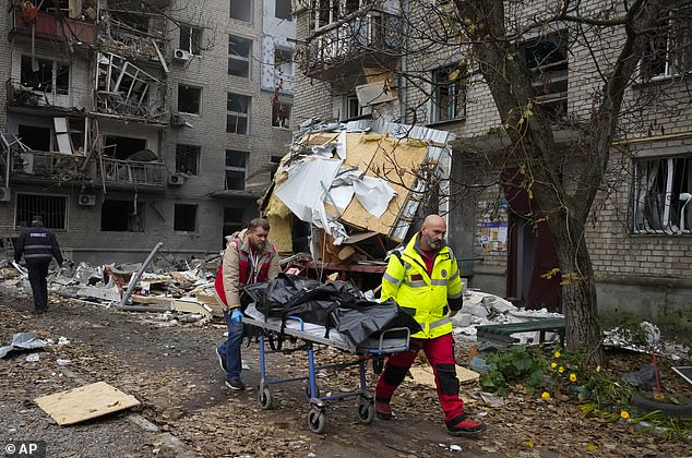 Los médicos llevan el cuerpo sin vida de una víctima encontrada bajo los escombros en la escena del bombardeo nocturno en Mykolaiv, Ucrania.