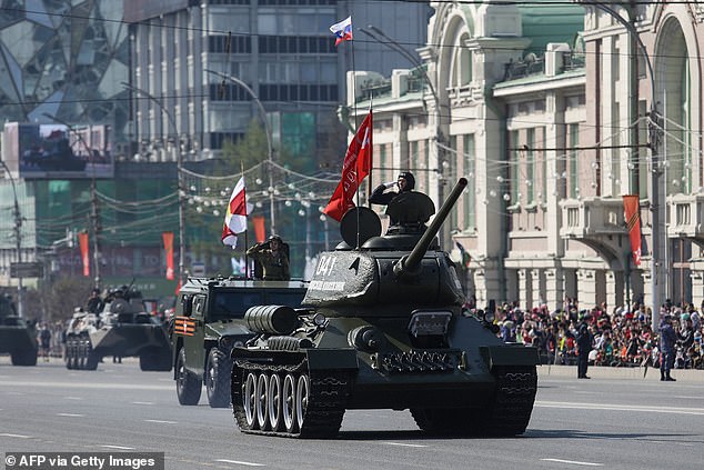 Un tanque T-34 de la era soviética y otros vehículos militares recorren la ciudad de Novosibirsk durante un desfile militar para conmemorar el 77 aniversario de la victoria soviética sobre la Alemania nazi en la Segunda Guerra Mundial, el 9 de mayo de 2022.