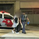 Oficiales de policía caminan con un hombre inglés que había sido secuestrado y rescatado, en Sao Paulo, Brasil, después de que se enamoró de un esquema de aplicación de citas.