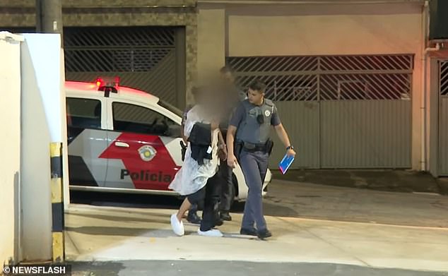 Oficiales de policía caminan con un hombre inglés que había sido secuestrado y rescatado, en Sao Paulo, Brasil, después de que se enamoró de un esquema de aplicación de citas.