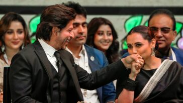 Los fanáticos de Shah Rukh Khan aplauden en voz alta cuando recibe un beso de Rani Mukerji y toca los pies de Amitabh Bachchan.  ver fotos