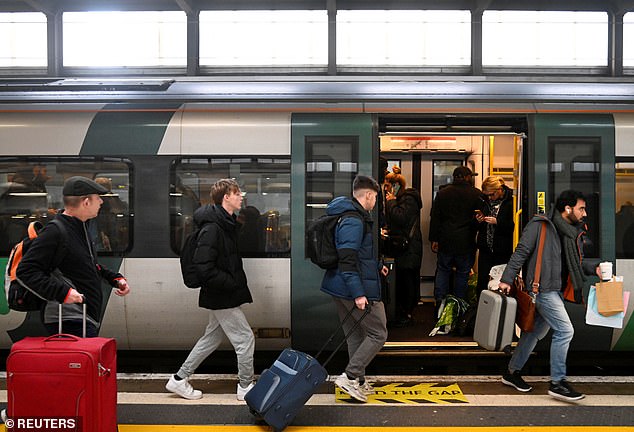 Los pasajeros que intentaban llegar a casa para Navidad el 24 de diciembre se enfurecieron cuando enfrentaron interrupciones debido a la huelga de los trabajadores ferroviarios por salarios y condiciones.  En la imagen: las personas abordan un tren en la estación de Euston