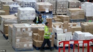 Un trabajador recolectando suministros en el Almacén Nacional de Adquisiciones del NHS en Canderside, Larkhall