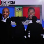 Los partidarios del senador demócrata Raphael Warnock miran CNN en un jumbotron mientras se informa el total de votos en Georgia el martes por la noche.