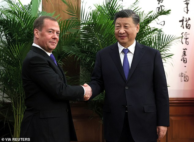 El vicepresidente del Consejo de Seguridad de Rusia, Dmitry Medvedev, estrecha la mano de Xi Jinping ayer en Beijing