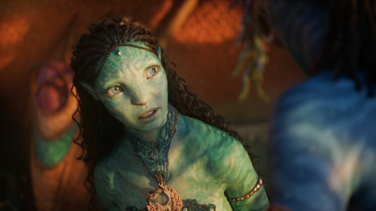 Tsireya shining in sunlight, as she looks up with concern in Avatar: The Way of Water.