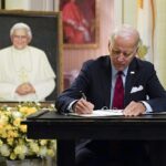 El presidente Joe Biden firma un libro de condolencias el jueves por la noche para el difunto Papa Benedicto, haciendo un viaje no anunciado a la embajada del Vaticano en Washington, DC