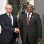 Russian president Vladimir Putin shakes hands with South African president Cyril Ramaphosa.