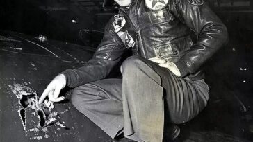 El capitán Royce Williams posa para una fotografía junto a un orificio de bala abierto en el fuselaje de su Panther que recibió 263 impactos durante su heroico combate aéreo contra los Mig rusos durante la Guerra de Corea en 1952.