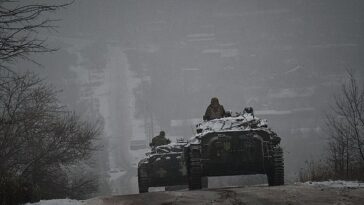 La guerra de Vladimir Putin en Ucrania no está cerca de terminar, y continuará prolongándose y volviéndose aún más sangrienta, advirtió el exjefe de la Marina Real, el almirante Lord Alan West.  En la imagen: los soldados ucranianos conducen vehículos blindados por una carretera helada en la región de Donetsk.