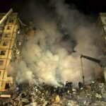 Los trabajadores de emergencia limpian los escombros después de que un cohete ruso impactara en un edificio de varios pisos dejando a muchas personas bajo los escombros en Dnipro, Ucrania, el sábado 14 de enero de 2023.