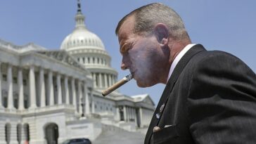 El representante Troy Nehls (R-TX) fuma un cigarro afuera del Congreso.  Las nuevas reglas significan que ahora puede fumar dentro del vestíbulo de la Cámara