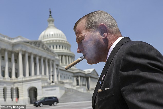 El representante Troy Nehls (R-TX) fuma un cigarro afuera del Congreso.  Las nuevas reglas significan que ahora puede fumar dentro del vestíbulo de la Cámara