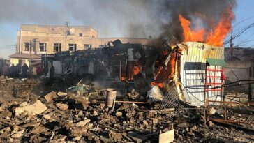 Un edificio se quema en un sitio de un mercado alcanzado por misiles rusos, en medio del ataque de Rusia a Ucrania, en la ciudad de Shevchenkove.