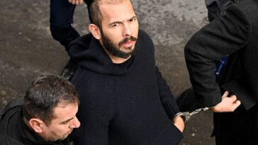 Andrew Tate llega esposado y escoltado por la policía a un juzgado en Bucarest el 1 de febrero de 2023