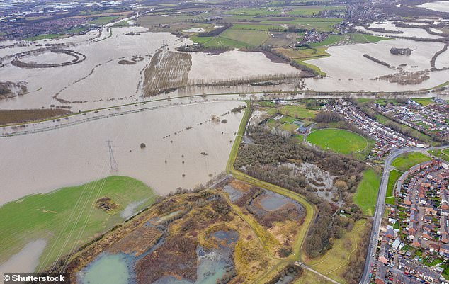 Los investigadores dijeron que el país podría enfrentar alrededor de 14 pulgadas (35 cm) de aumento del nivel del mar en comparación con los niveles históricos dentro de 30 años y es casi seguro que verá cerca de 3 pies (1 m) de avance para fines de siglo.  Aquí, una foto aérea de un dron de la ciudad de Allerton Bywater cerca de Castleford en Leeds, West Yorkshire, muestra los campos inundados por el río Aire.