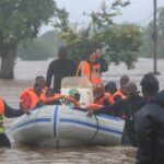 Rescue personnel evacuate residents on boat from the floods caused by heavy rain in the Boane district of Maputo on 11 February 2023.
