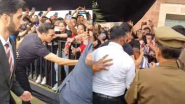 La seguridad de Akshay Kumar aborda al hombre que saltó las barricadas por él, el actor lo abraza en su lugar.  Mirar
