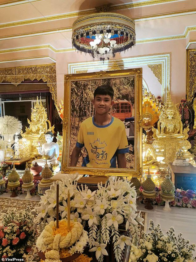 Madre Thanaporn Phromthep se unió a amigos y familiares mientras realizaban ritos religiosos para Duangphet 'Dom' Phromthep (visto en una fotografía en la ceremonia), de 17 años, en el templo Wat Phra That Doi Wao en la provincia de Chiang Rai, Tailandia, el 16 de febrero.