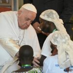 Pope Francis (L) blesses attendees as he meets wit