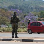 A soldier stands in the road in Manzini during unrest in Eswatini.