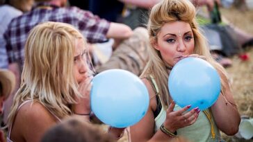 Un neurólogo ha advertido de que el óxido nitroso, un gas que algunos jóvenes inhalan de forma recreativa, es más peligroso que la cocaína.  En la imagen: los juerguistas chupan globos en un festival de música, una forma común en que las personas inhalan óxido nitroso.